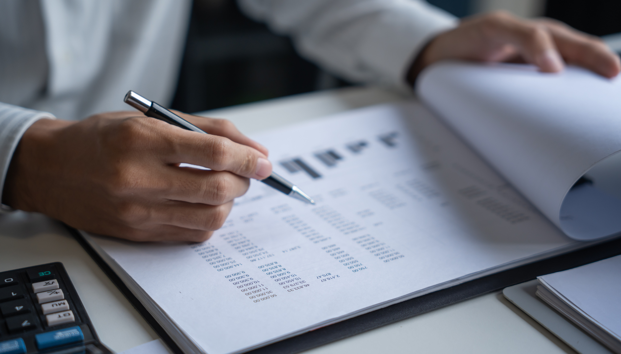 Benchmark Forum Osoba analizuje dane finansowe i wykresy podczas spotkania biznesowego. Zdjęcie nawiązuje do analiz porównawczych, benchmarków finansowych oraz projektowanych zmian w zakresie cen transferowych.